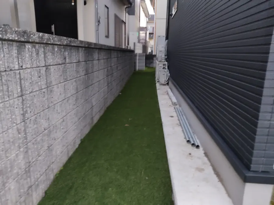 草抜きの負担を減らすため建物脇に敷いた人工芝