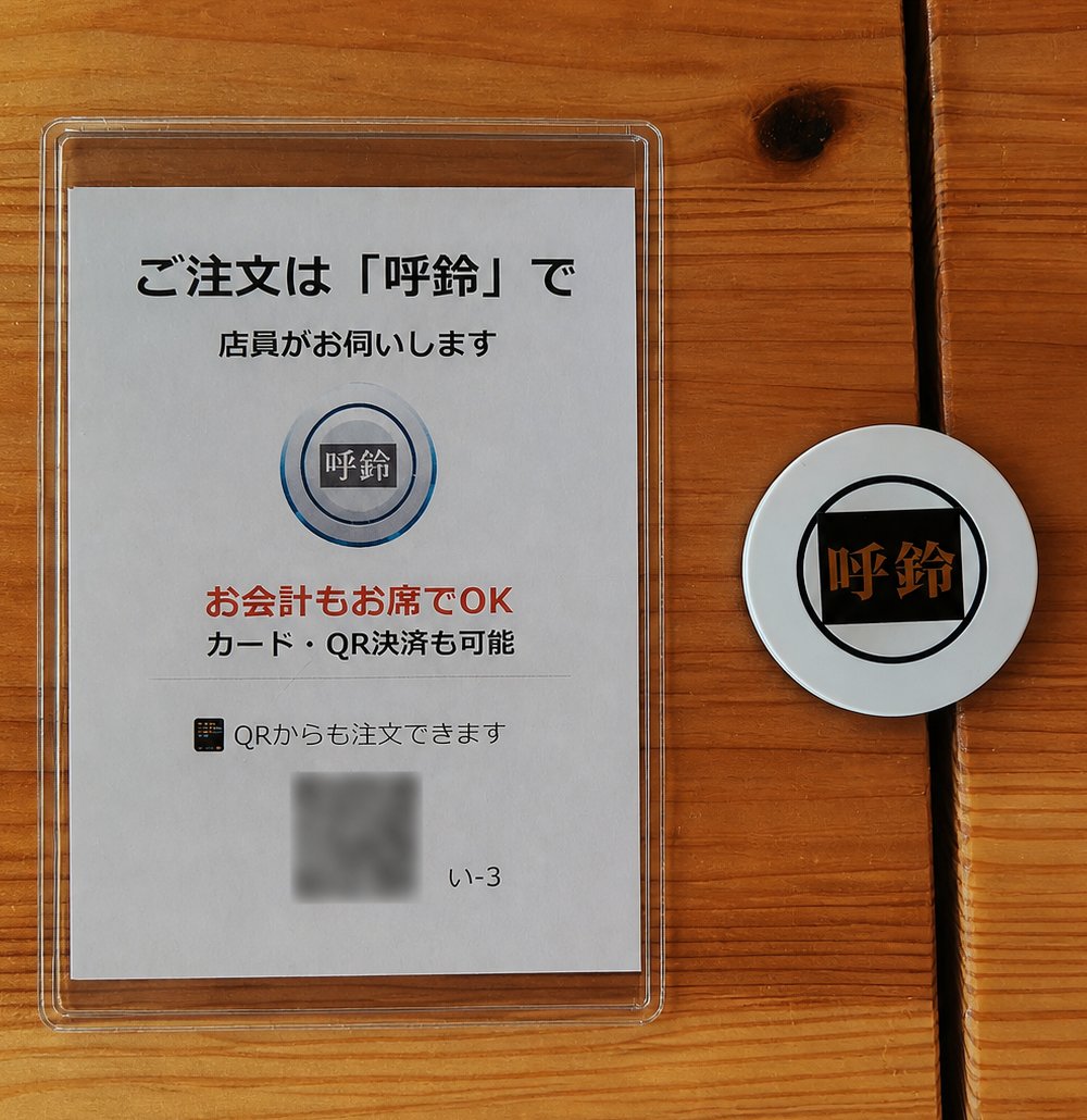 実際の卓上に並ぶ呼鈴ボタンとQR注文の案内